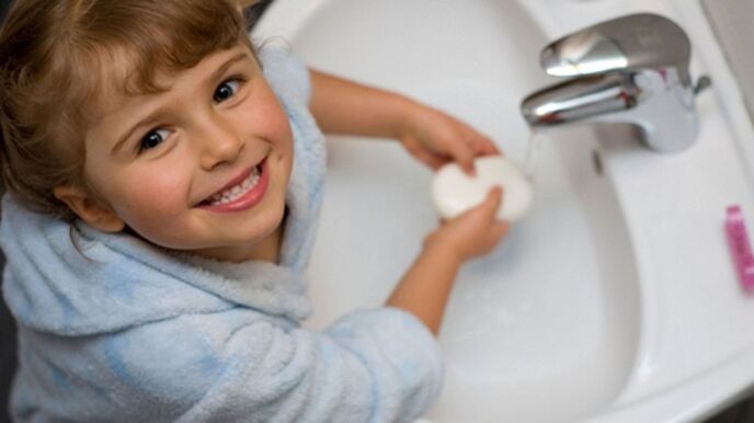 otrok si umiva roke z milom, da prepreči črve